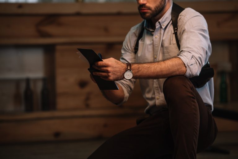 Cropped view of male detective making notes